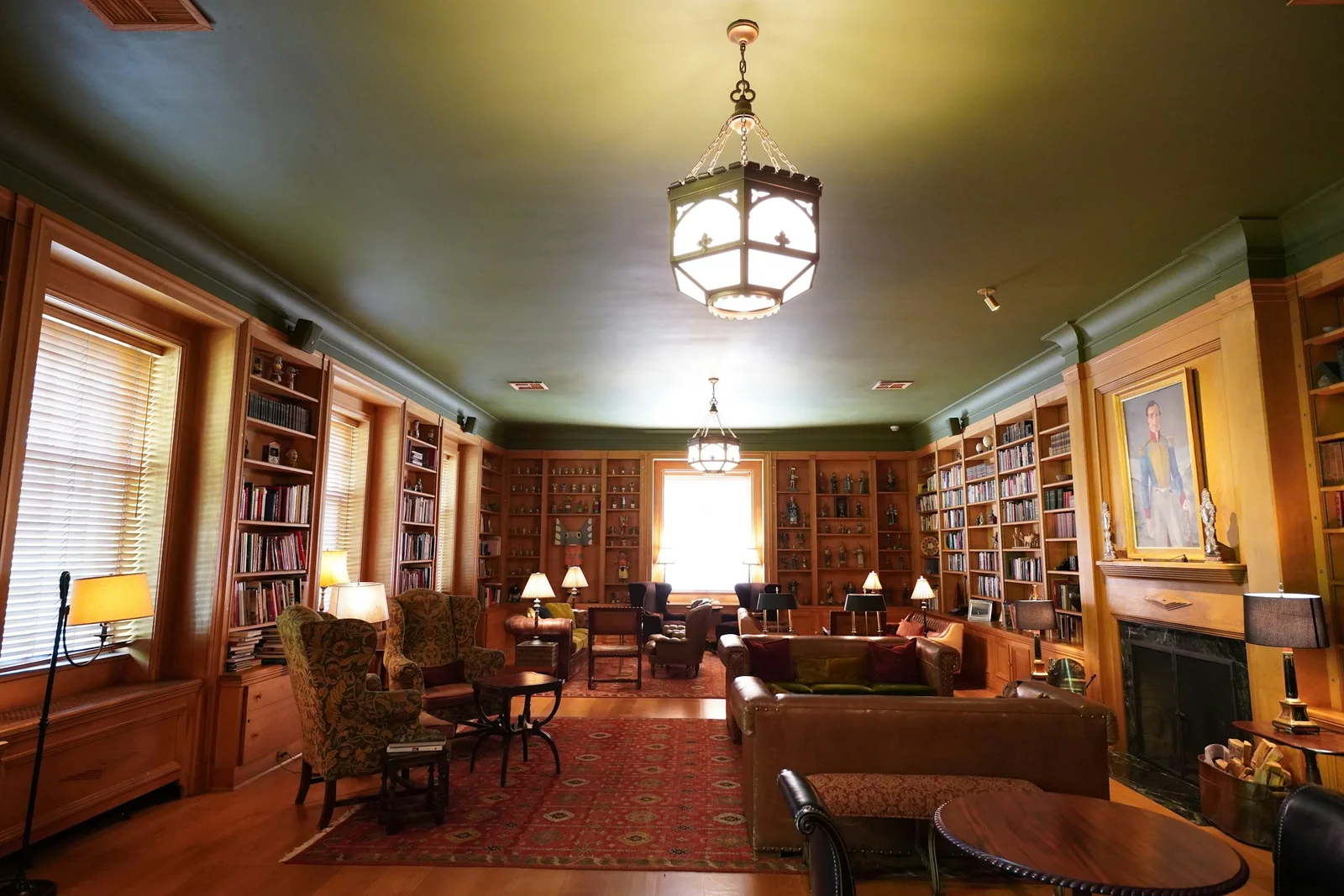 Historic library with wooden bookshelves, antique seating and warm pendant lighting